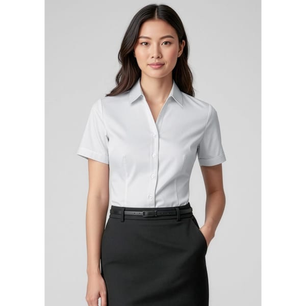 A short sleeve button-up shirt in white, featuring a collar and a fitted design, paired with a black skirt.