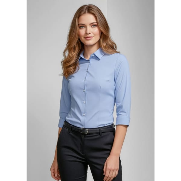 A light blue women's button-up shirt with 3/4 sleeves and a fitted design, featuring a logo.