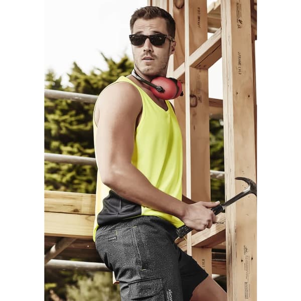 A men's hi-vis singlet in bright yellow with black accents, worn with sunglasses and hearing protection, against a timber backdrop.