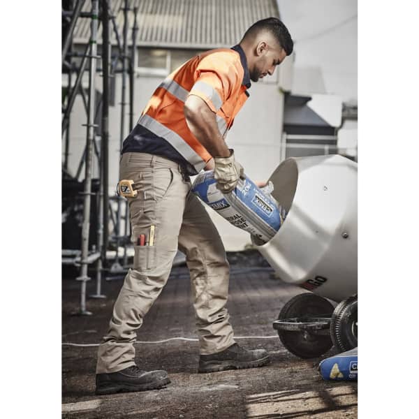 Men's rugged cooling cargo pants in khaki, featuring multiple pockets and a tool belt, worn by a worker on a construction site.