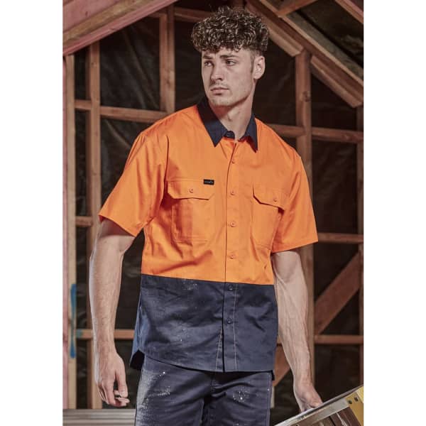 A short sleeve work shirt in bright orange and navy blue, featuring two chest pockets and a logo.