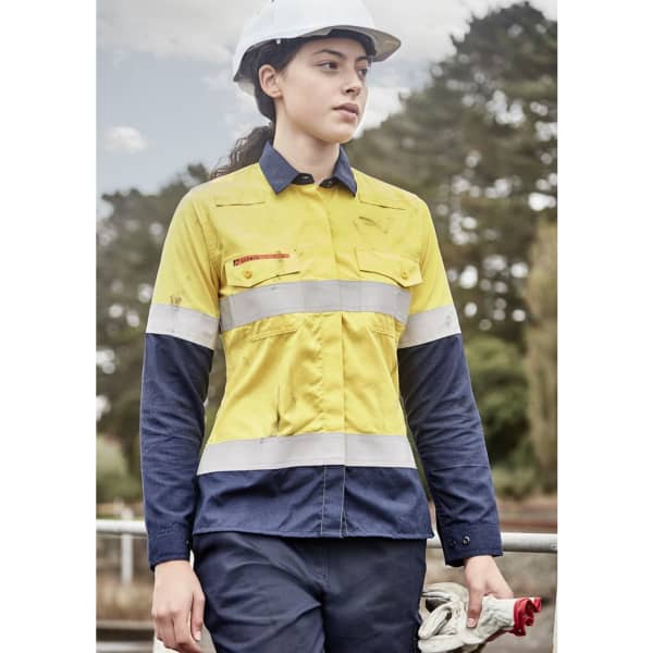 A lightweight women's shirt in orange and navy, featuring reflective taping and a logo. Suitable for workwear.