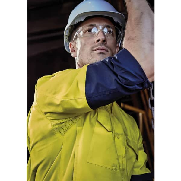 A men's long sleeve work shirt in yellow and navy blue, featuring a logo, worn by a person in safety gear.