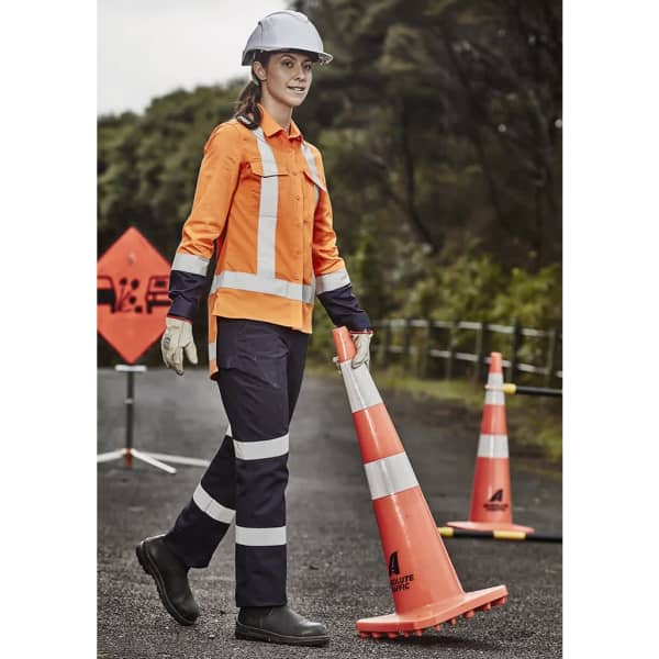 An orange and navy blue women's drill work shirt with reflective strips, worn with heavy gloves and a hard hat.