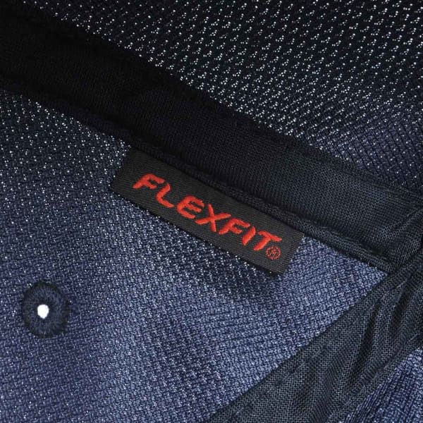 A close-up of a navy blue cap featuring a label with the brand name FLEXFIT.