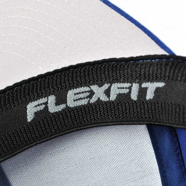 A blue and white cap featuring a black strap with a branding logo. The cap is part of the V-FLEXFIT product line.