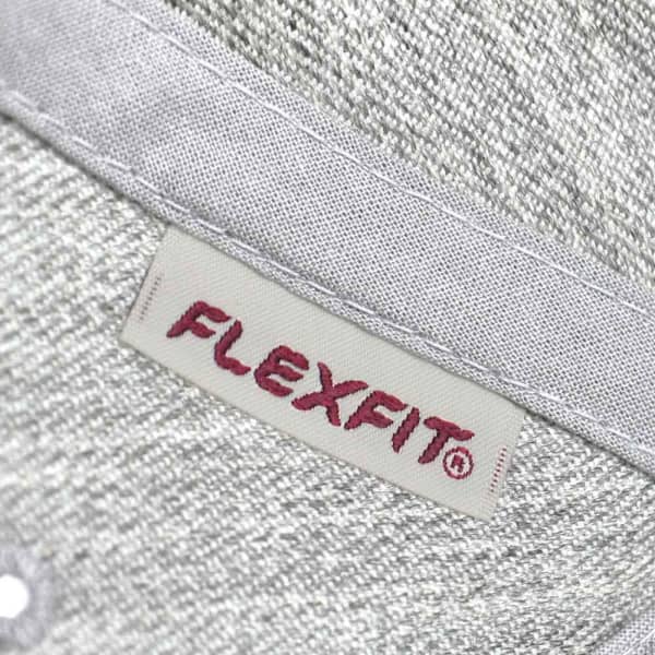 A grey cap featuring a textured fabric and a logo label on the interior band.