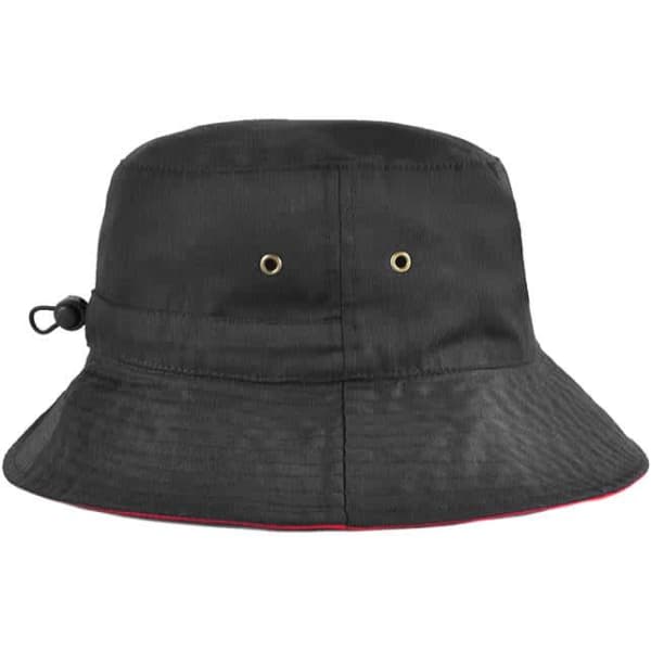 A reversible black bucket hat with an adjustable toggle and gold eyelets, featuring a red trim.
