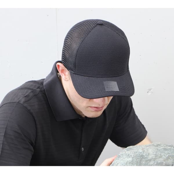 A black nylon/mesh cap with a logo, styled with a fitted design and mesh panels for breathability.
