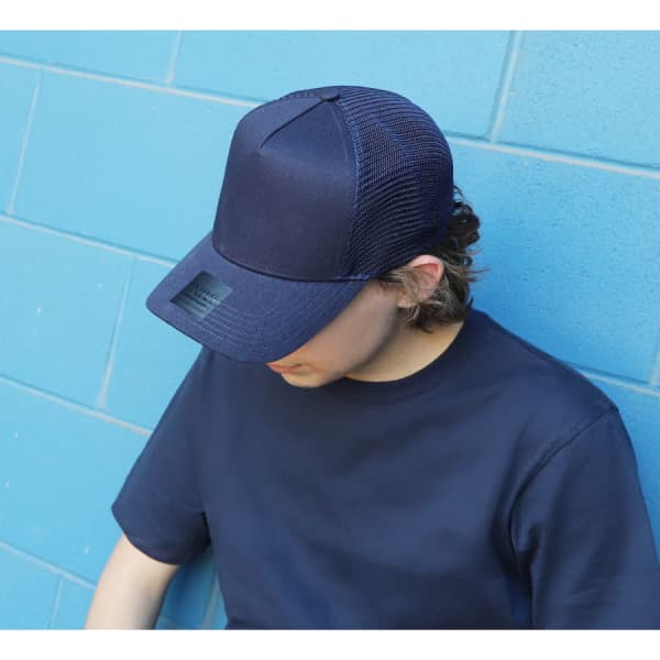 A navy blue cap with a mesh back, resting on the head of a person wearing a matching navy shirt.