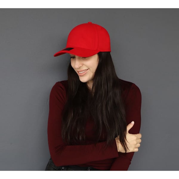 A red cotton/spandex cap is worn by a woman with long dark hair, smiling against a grey background.