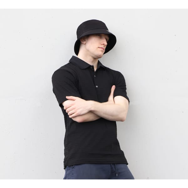 A black cotton/spandex bucket hat displayed on a model wearing a matching black polo shirt. The hat features a logo.