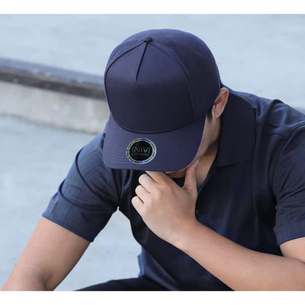 A navy blue cap made from polycotton, featuring a round logo on the front.