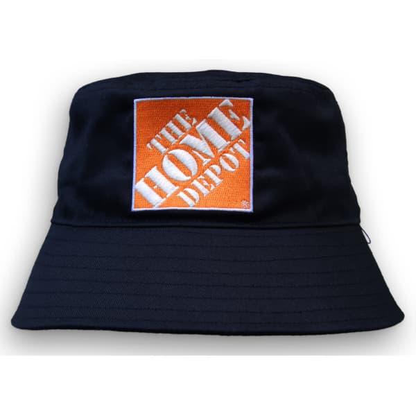 A navy blue bucket hat with a square logo in orange and white, featuring a wide brim and textured fabric.