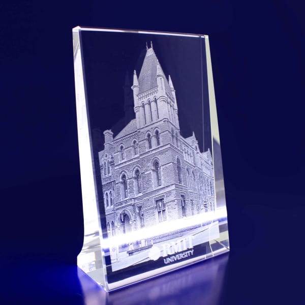 A clear 3D crystal photocrystal featuring a detailed building engraving with a logo at the base.