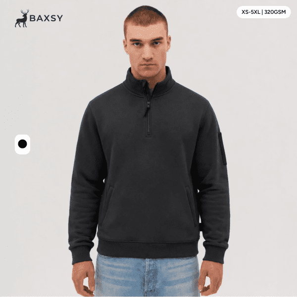 A 1/4 zip fleece in dark grey, featuring a logo on the sleeve. Model displays the product against a neutral background.