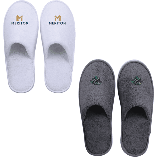 Two pairs of hotel slippers: one in white with a logo, the other in grey with a leaf design.