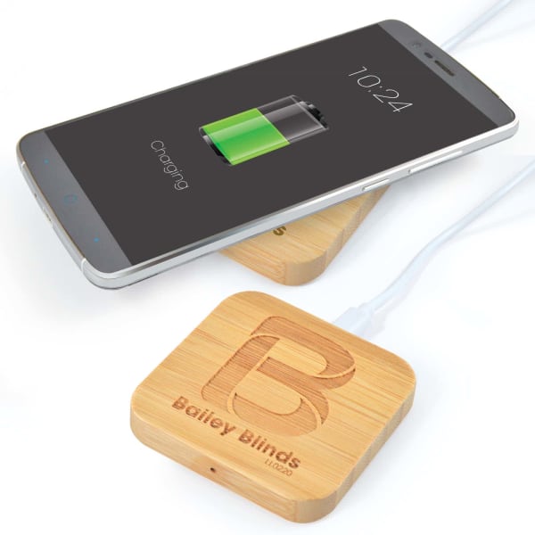 A bamboo wireless charger in a square shape with a smartphone on top, displaying a charging battery icon.