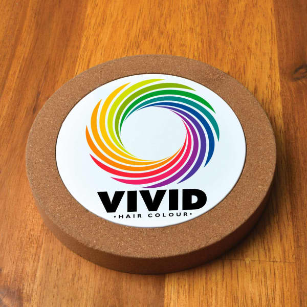 A circular cork wireless charger featuring a colourful, spiral design and a prominent logo in the centre.
