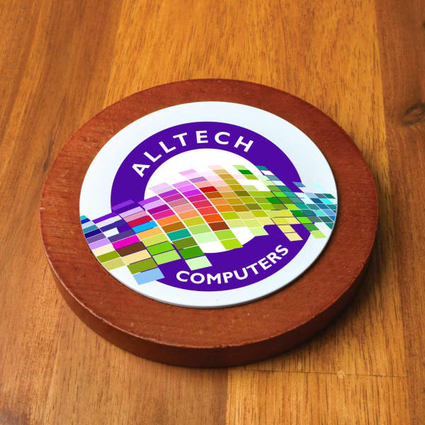 A circular wooden coaster featuring a colourful design and a logo for Alltech Computers.