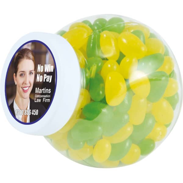 A container filled with green and yellow jelly beans, featuring a branding label on the side.