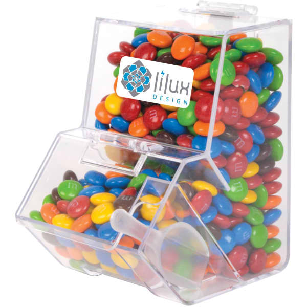 A clear dispenser filled with colourful M&M's, featuring a branding logo on the front.