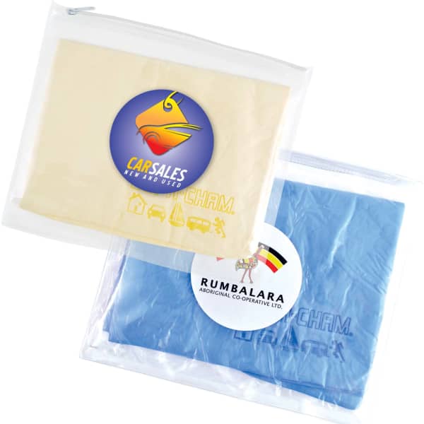 A transparent pouch containing a cream and a blue chamois, both with logos.