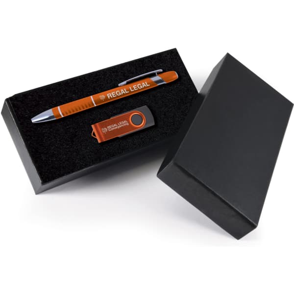 A black gift box containing an orange pen and an orange USB drive, both featuring branding.