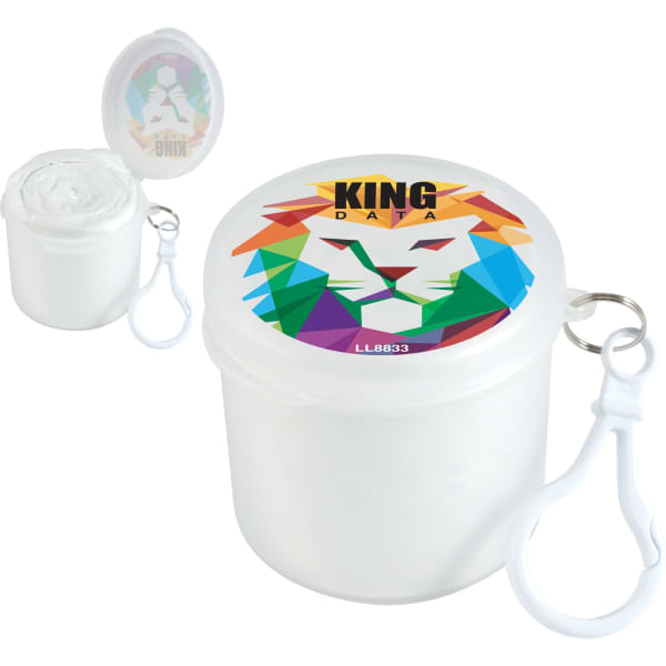 A white container with a colourful lion design on the lid, holding a roll of material and featuring a clip attachment.