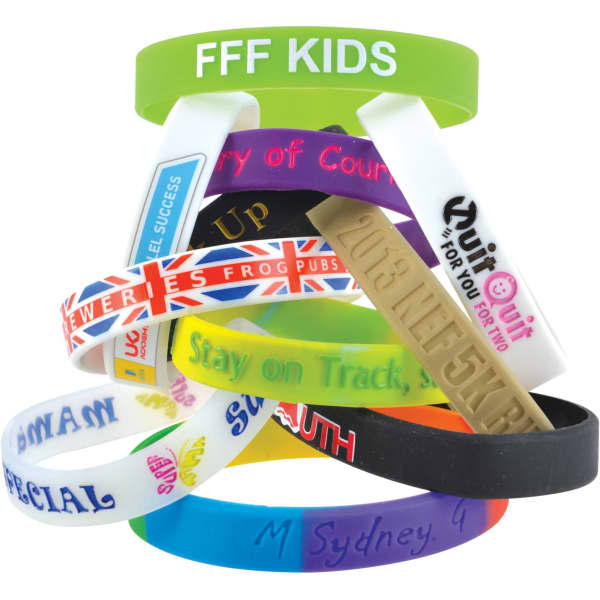 A stack of multi-coloured silicone wristbands featuring various designs and a logo on one band.