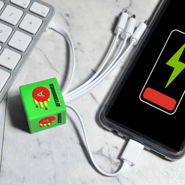 A green Cube Topper PVC charging cable with multiple connectors attached to a smartphone and keyboard.