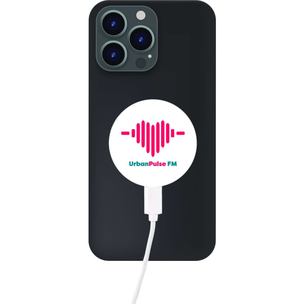 A black phone with a circular white and pink magnetic wireless charger attached to it. The charger has a logo.