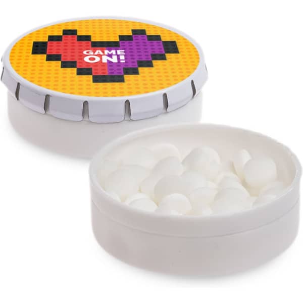 A round mint tin with a colourful lid featuring a heart design, filled with small white mints.