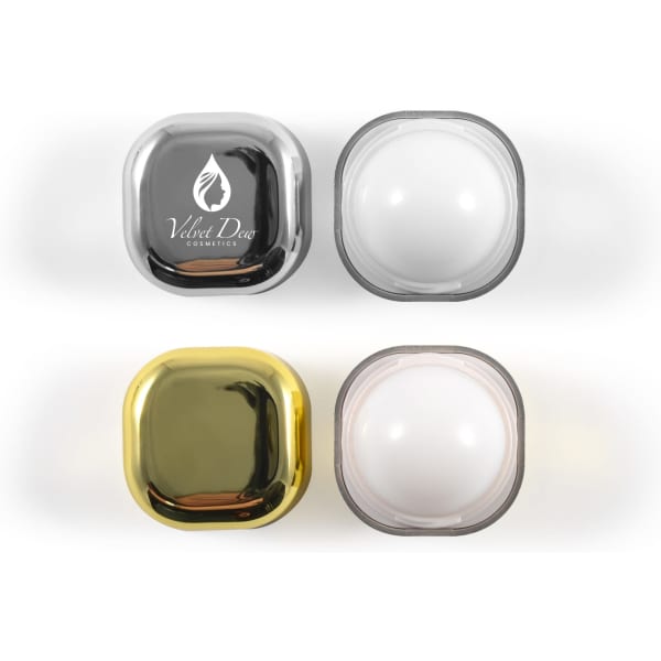 A set of four square lip balm containers in black, white, and gold colours, featuring branding on the black container.