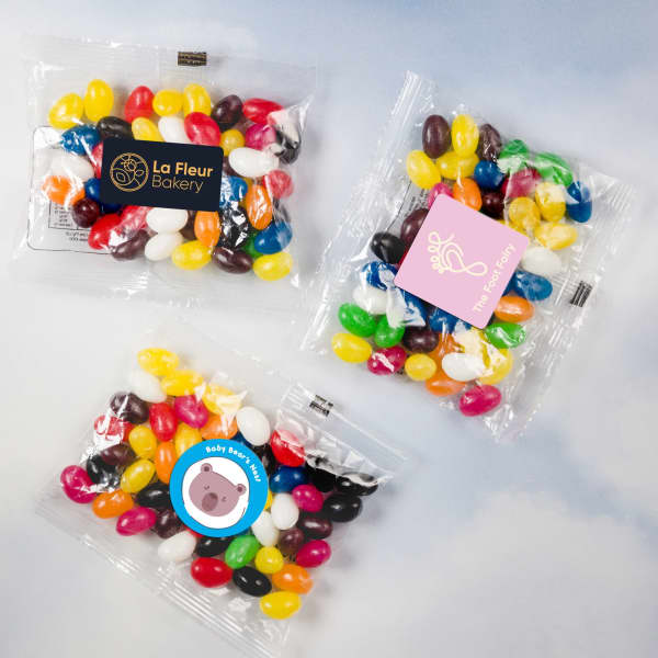 Assorted mini jelly beans in various colours, packaged in clear cello bags, featuring different logos.