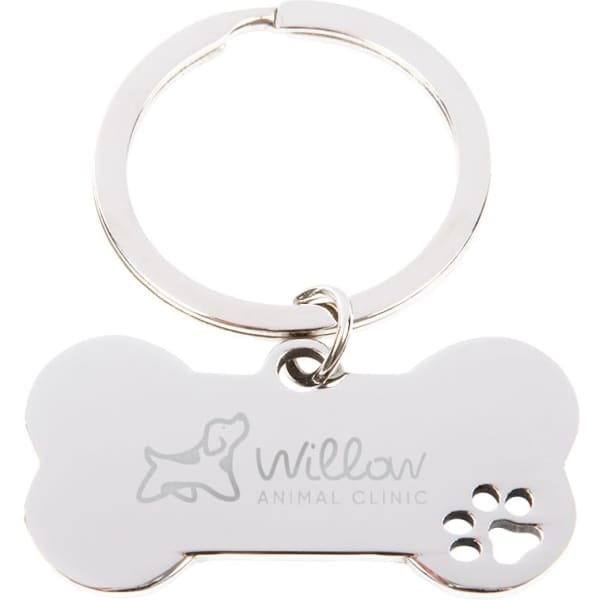 A silver dog bone-shaped keytag featuring a logo and a paw print design. The tag has a metal keyring attached.