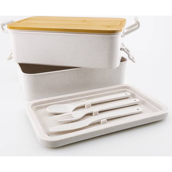 A dual-compartment lunch box with a yellow lid, featuring white utensils and an inner tray. It has a logo on the side.