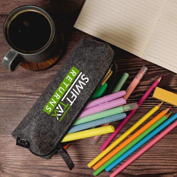A grey felt utility case filled with colourful pens and markers, alongside a cup of coffee and a notebook.