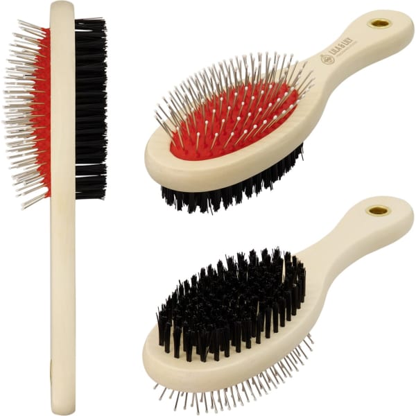 A pet grooming brush featuring a mix of black and red bristles with a light cream handle. Includes a logo.