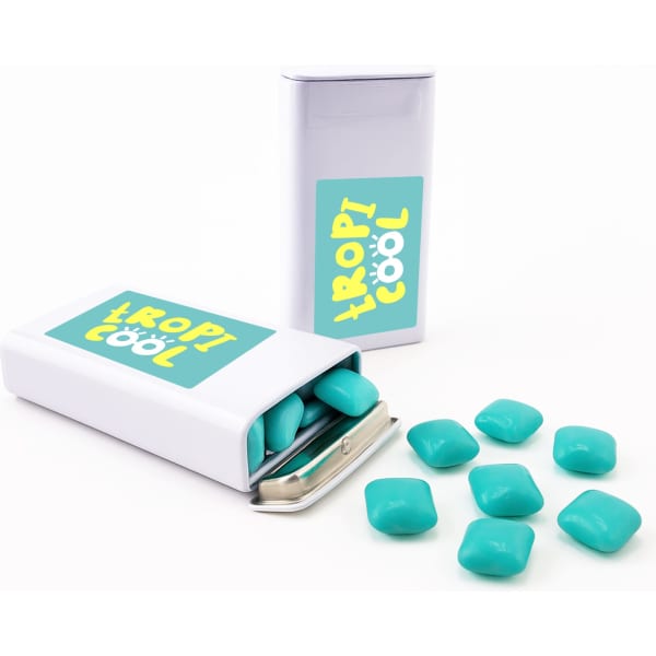A tin of chewy peppermint mints in a white and turquoise container, with several mints scattered around.