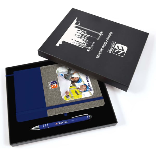 A gift box containing a grey notebook with blue accents and a blue pen, featuring a logo.