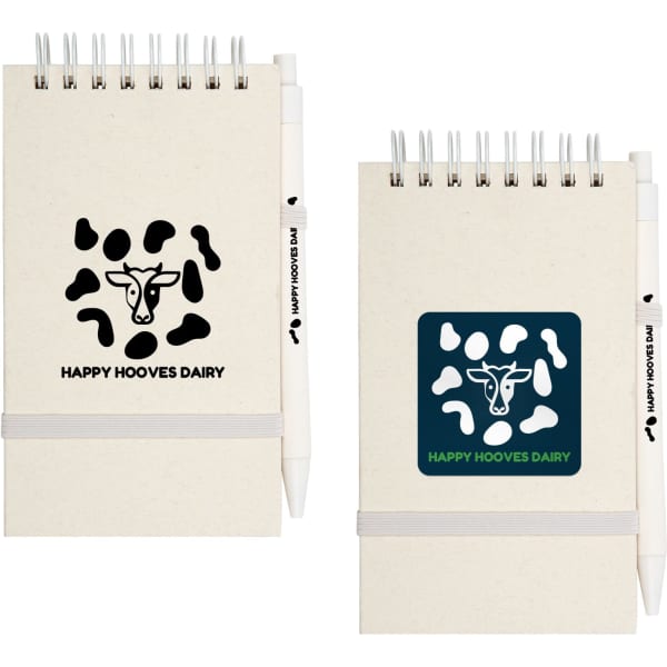 A notepad with a cow-themed design in beige and black, accompanied by a white pen, featuring a logo.