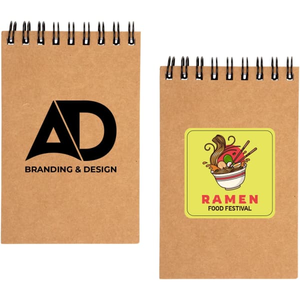 A brown spiral pocket notebook featuring a logo and a vibrant ramen-themed sticker on the cover.