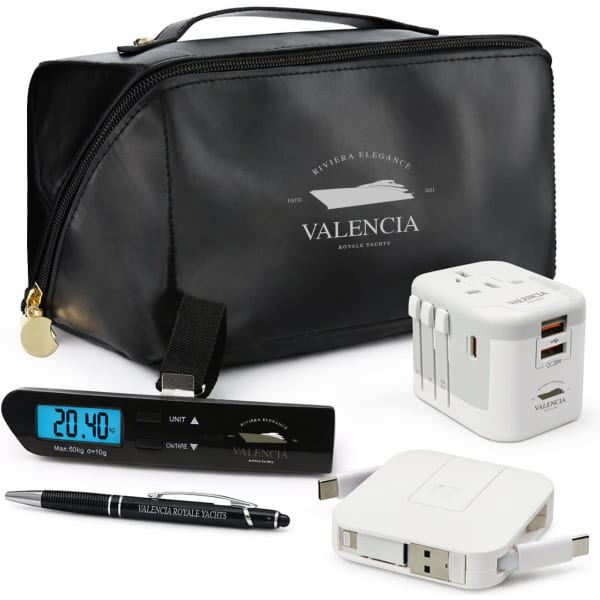 A black toiletry bag, clock, pen, and multi-port charger with a logo, all arranged together.
