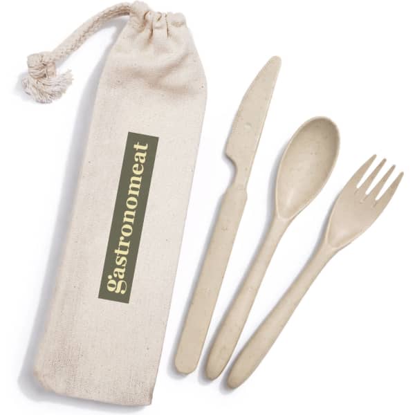 A calico pouch containing a beige cutlery set with a knife, fork, and spoon. The pouch features a logo.