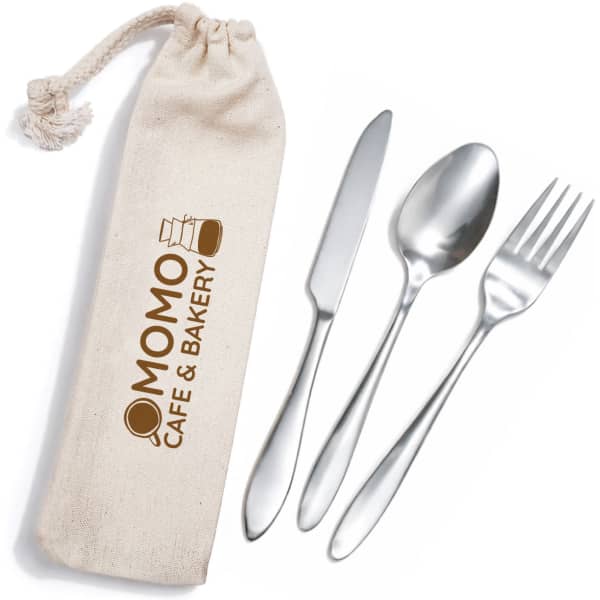 A cutlery set in silver with a fork, spoon, and knife, stored in a beige calico pouch featuring a logo.