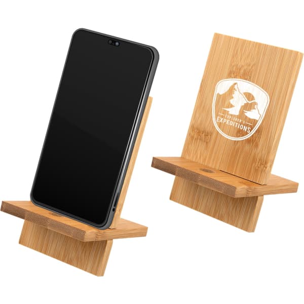 A bamboo phone stand displaying a smartphone, featuring a logo on the back. Natural wood finish.