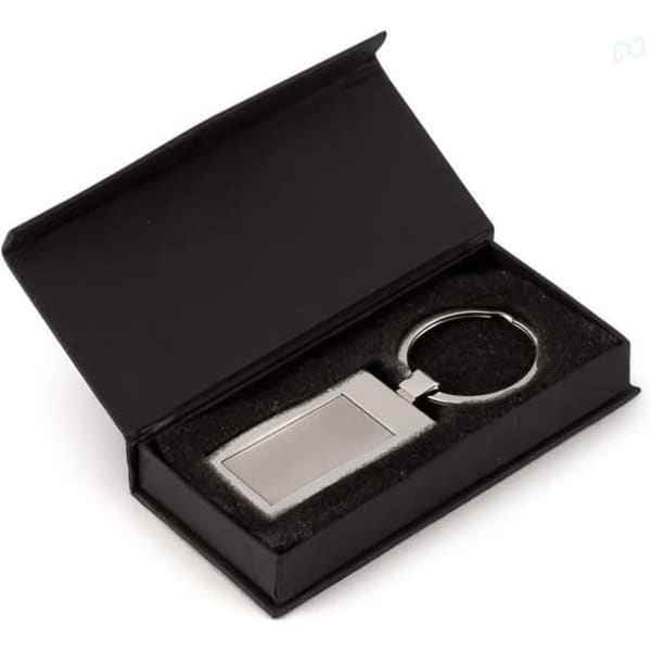 A silver keyring with a rectangular charm, presented in a black box with a soft interior.