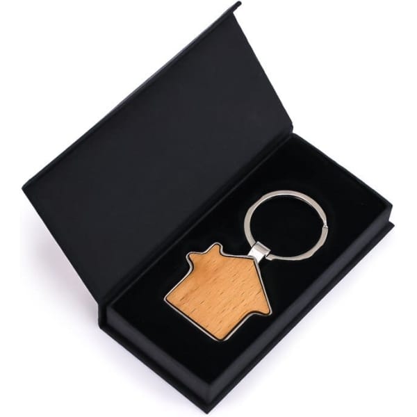 A wooden house-shaped keyring in a black presentation box, featuring a silver keyring attachment.