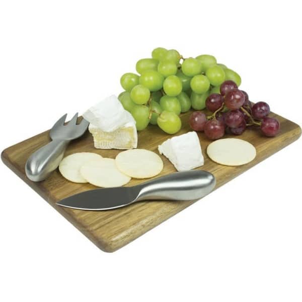 A wooden rectangular cheese board featuring assorted cheeses, green and red grapes, and stainless steel cheese knives.